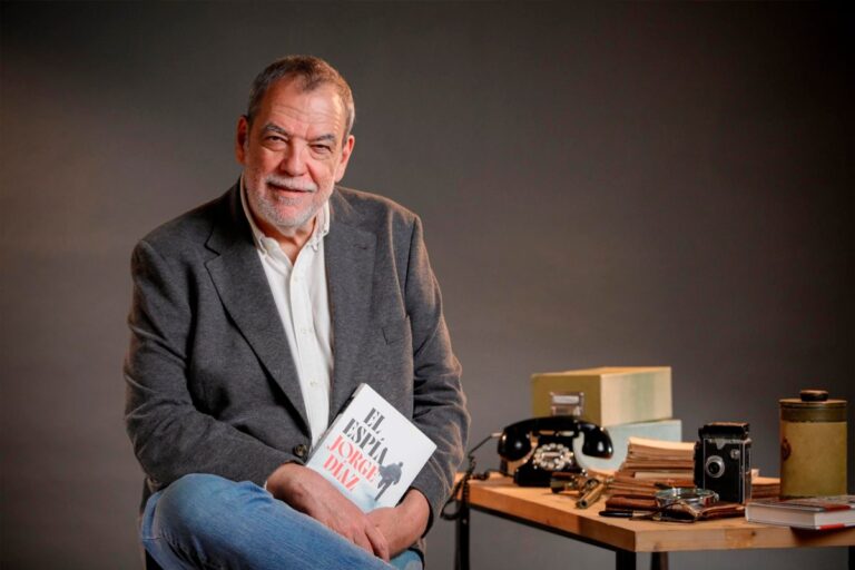 Jorge Díaz Cortés sosteniendo su libro en un evento literario