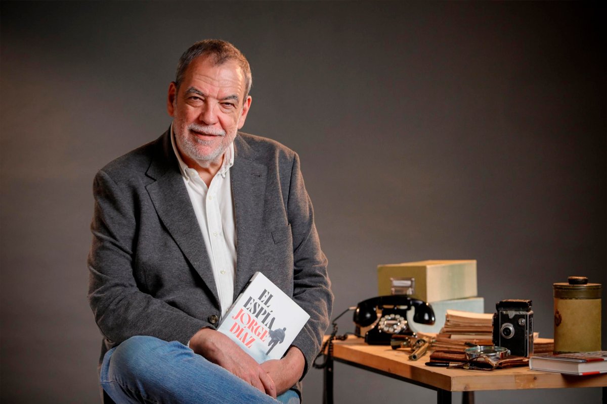 Jorge Díaz Cortés sosteniendo su libro en un evento literario