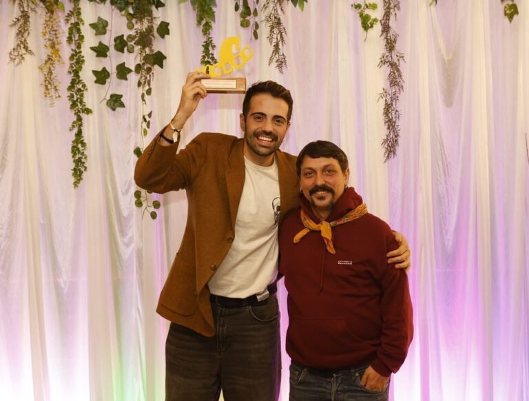 Kike García y Castora Herz sosteniendo un premio en un evento