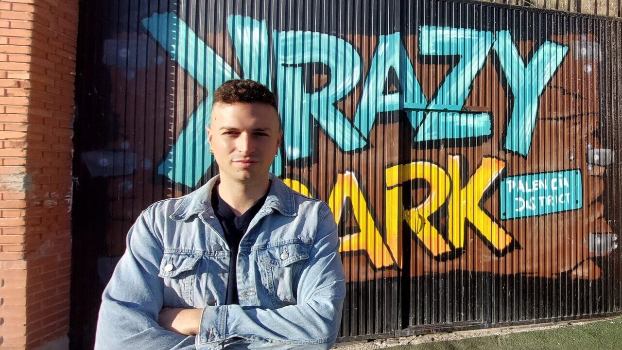 Entrada de Krazy Park con un mural colorido y una persona posando.