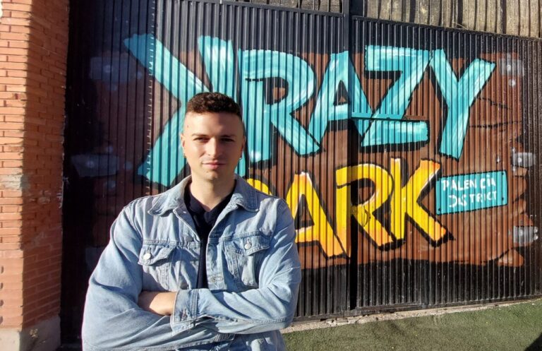 Entrada de Krazy Park con un mural colorido y una persona posando.