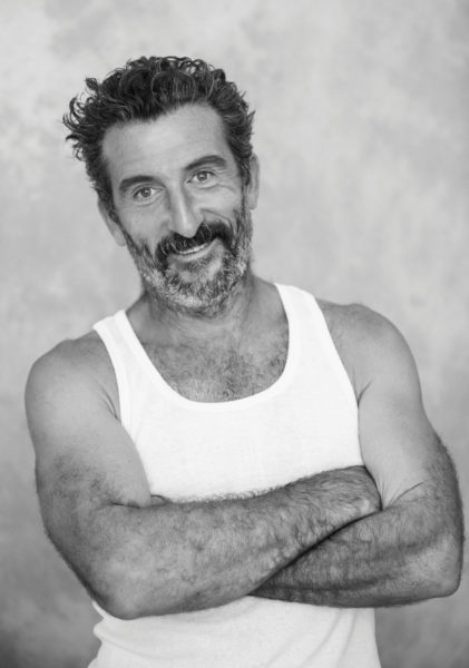 Luis Zahera sonriente con brazos cruzados en camiseta blanca