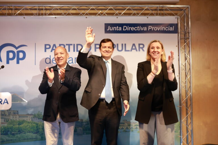 El presidente del PPCyL junto a otros miembros del partido aplaudiendo en un evento