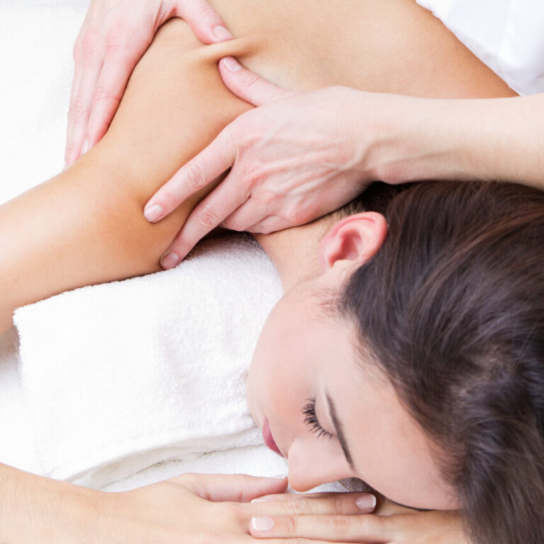 Una persona recibiendo un masaje en un entorno de bienestar.