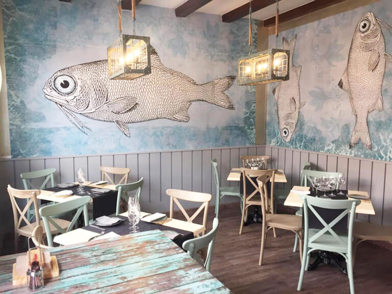 Interior del Mesón Gallego con decoración de peces y mesas preparadas