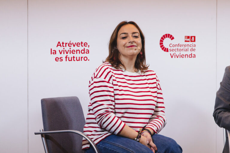 Miriam Andrés en conferencia sobre vivienda con fondo de texto.