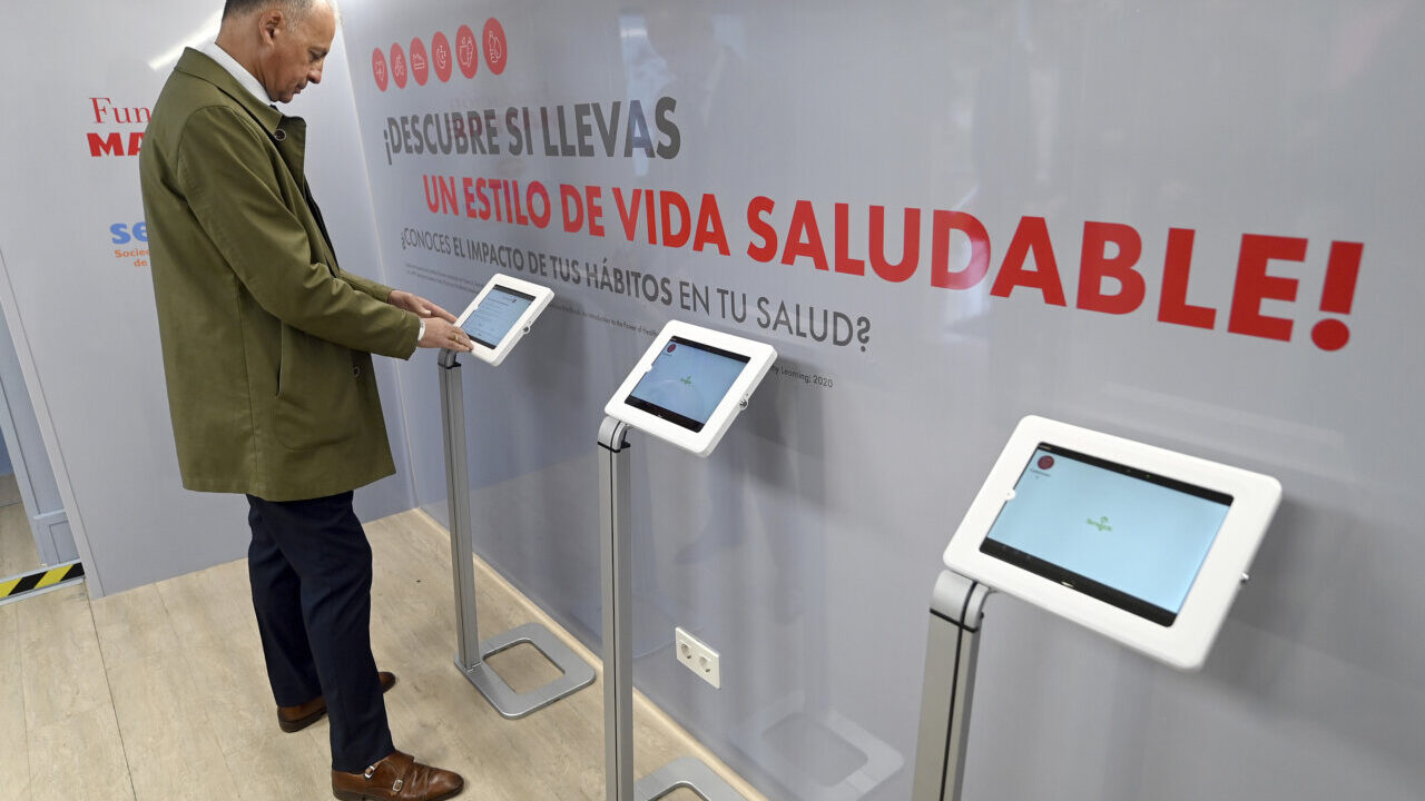 Hombre interactuando con pantallas sobre salud en evento de Mapfre