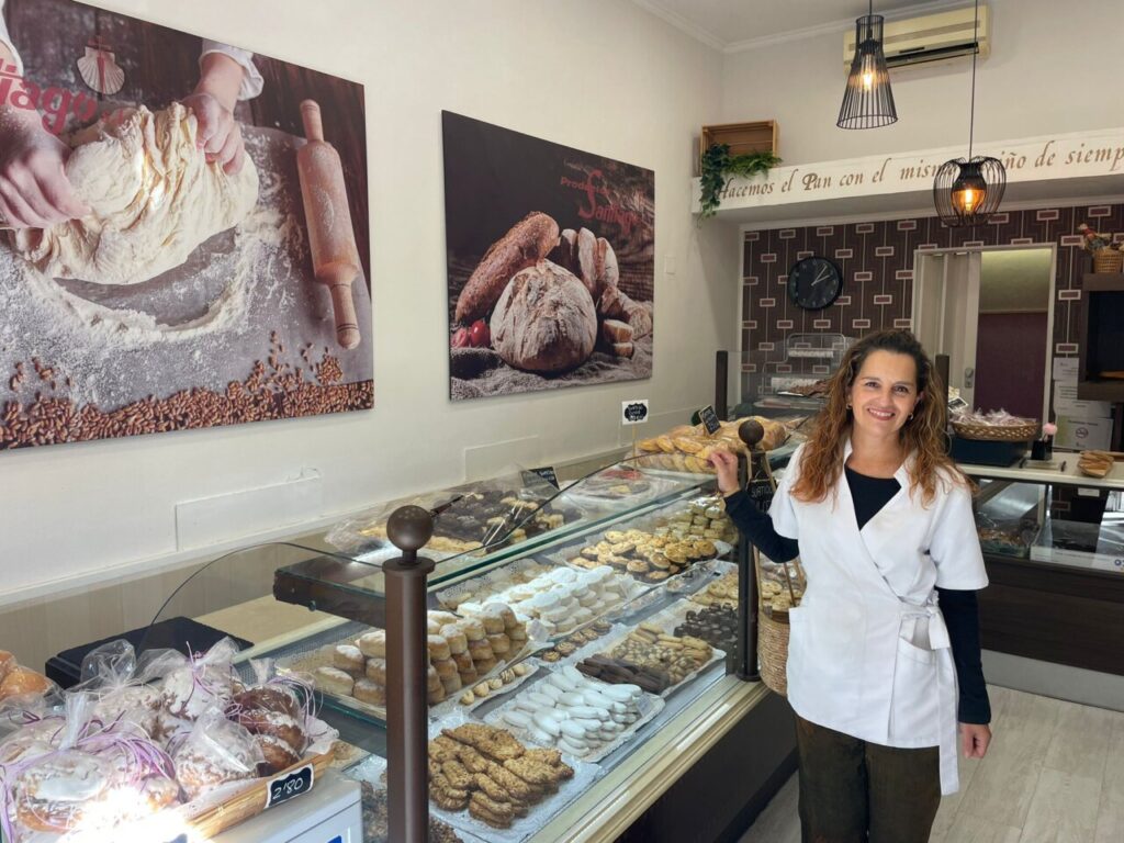 Interior de la panadería con variedad de productos y una trabajadora