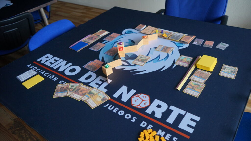 Mesa de juego con cartas y componentes del juego Bandas Doradas