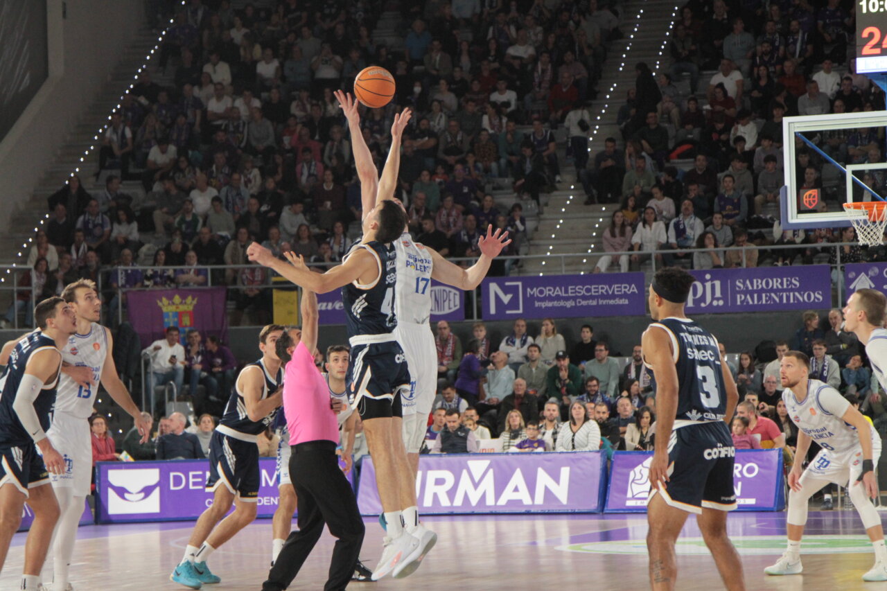 Jugadores de baloncesto en el salto inicial del partido entre Palencia y Oviedo.