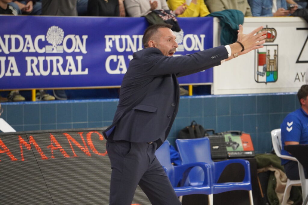 Entrenador dirigiendo a su equipo durante un partido de baloncesto.
