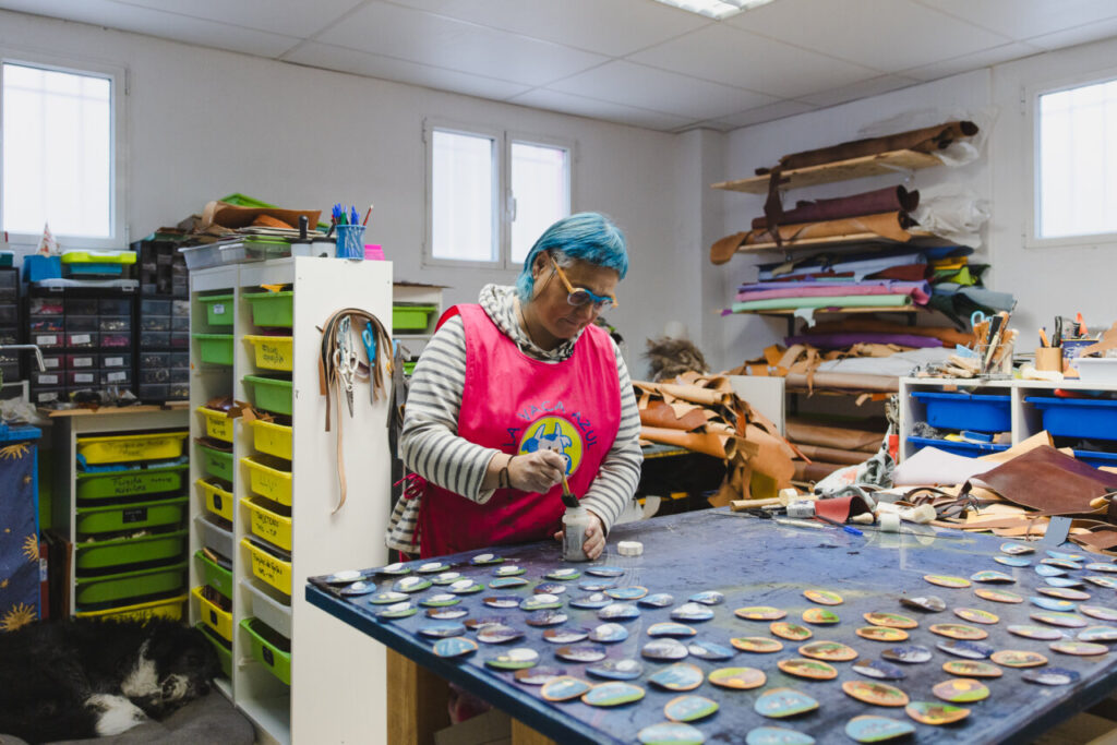 Mujer trabajando con cuero en un taller creativo.