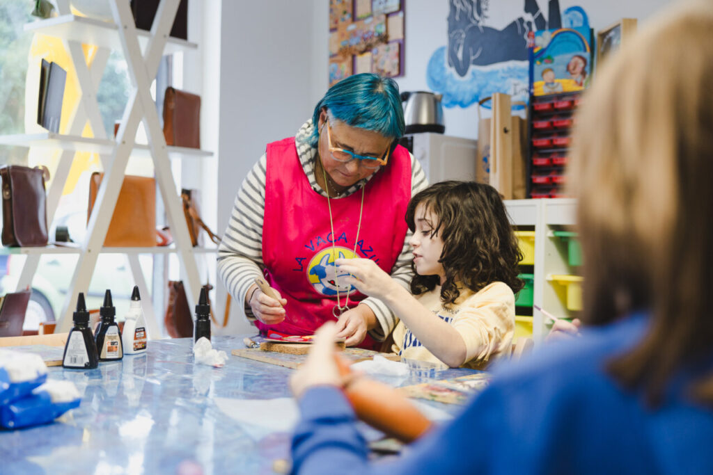 Maestra de cuero enseñando a un niño en un taller creativo