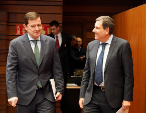 Dos hombres conversando en un entorno formal de reunión