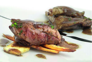 Plato de pichón estofado con guarnición de patatas paja