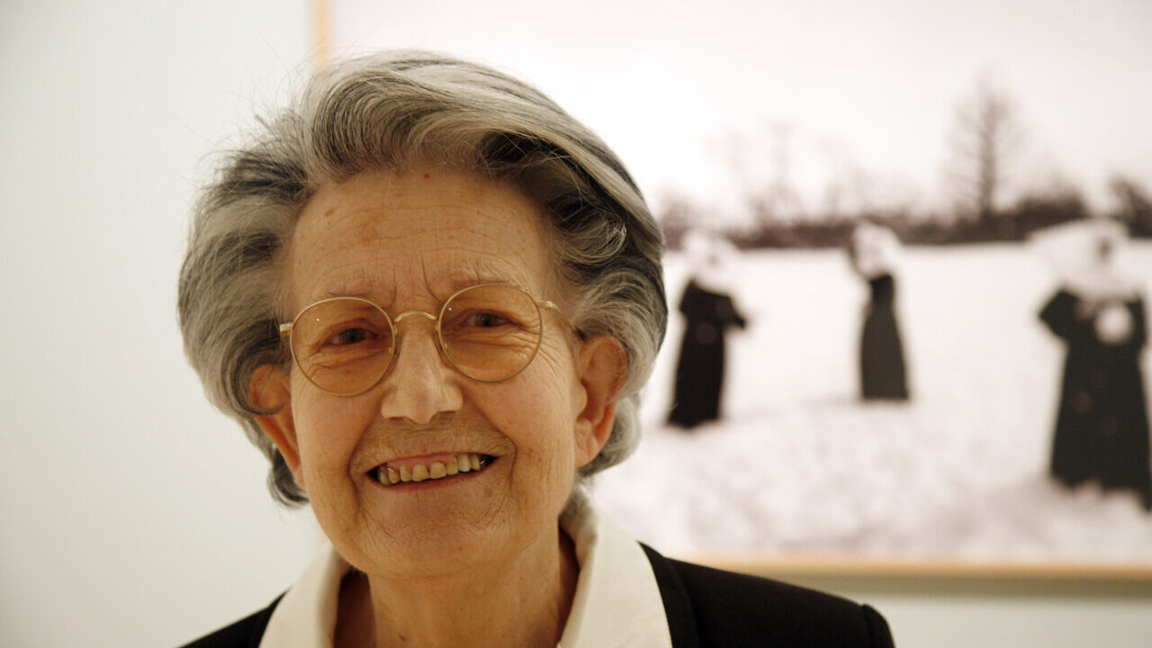 Piedad Isla sonriente en una exposición de su trabajo fotográfico