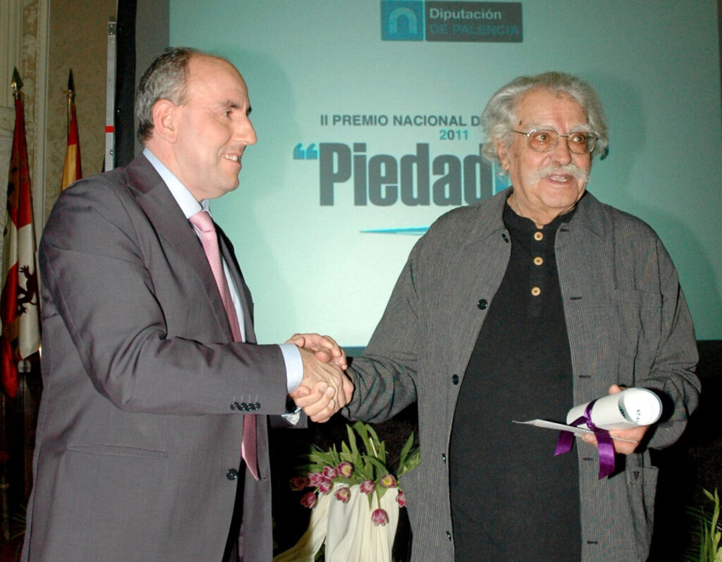 Ceremonia del Premio Nacional de Fotografía Piedad Isla con dos hombres estrechando manos.