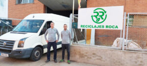 Dos hombres frente a la empresa Reciclajes Roca con una furgoneta blanca.