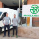 Dos hombres frente a la empresa Reciclajes Roca con una furgoneta blanca.
