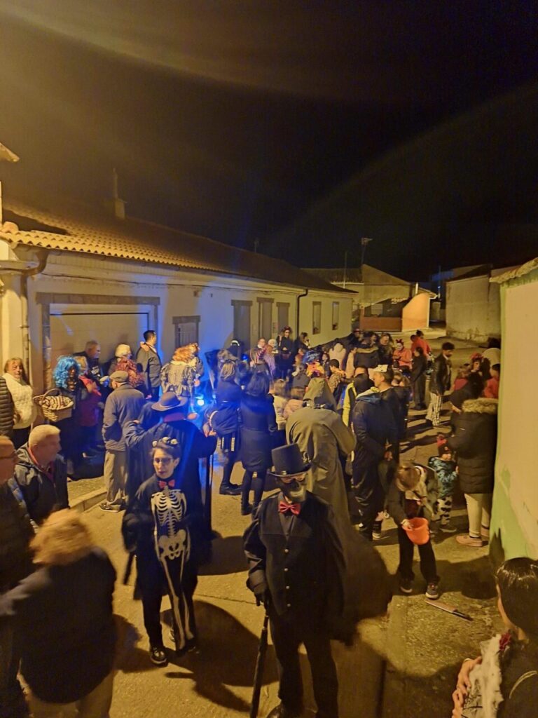 Niños y adultos disfrazados en las calles de Husillos durante Halloween