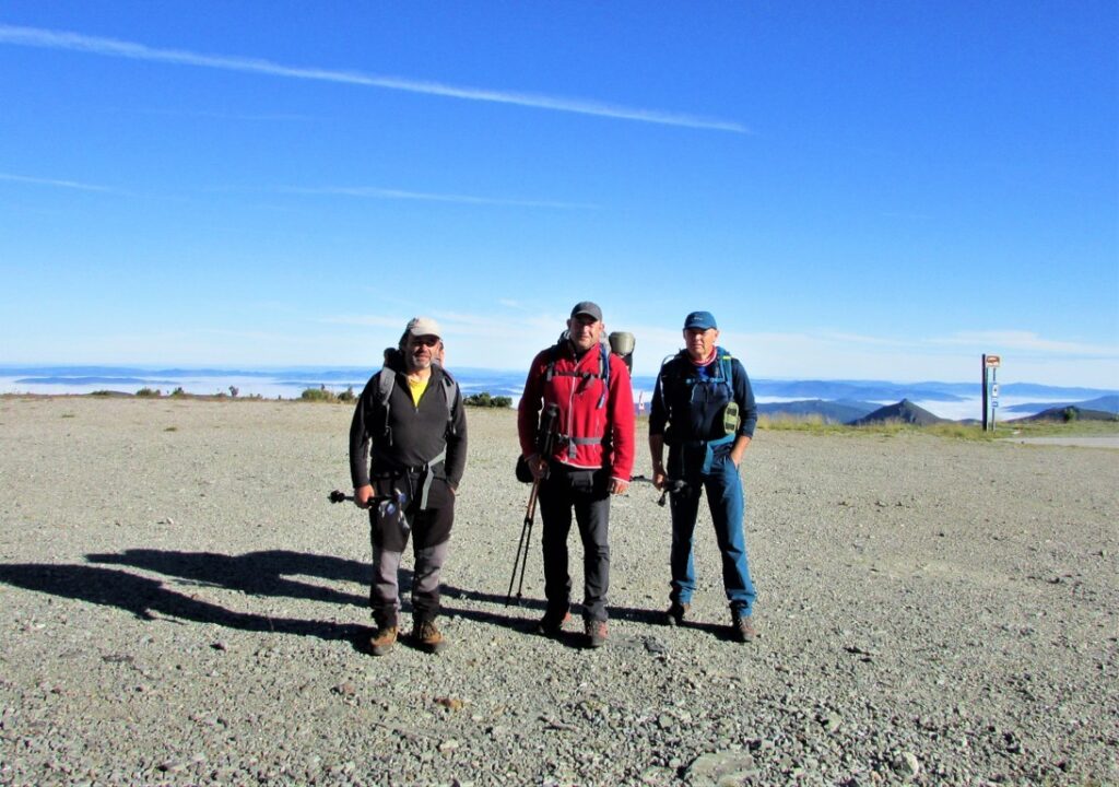 Tres montañeros en la Cordillera Cantábrica con fondo montañoso