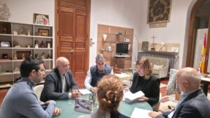Reunión institucional en Carrión de los Condes con varias personas en una mesa.