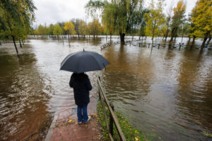 Persona con paraguas observando una inundación en Ciudad Rodrigo