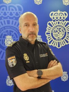 Retrato de Ricardo Gutiérrez, inspector de Policía Nacional, con fondo institucional.