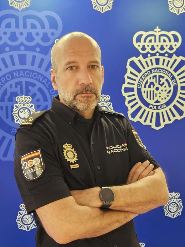 Retrato de Ricardo Gutiérrez, inspector de Policía Nacional, con fondo institucional.