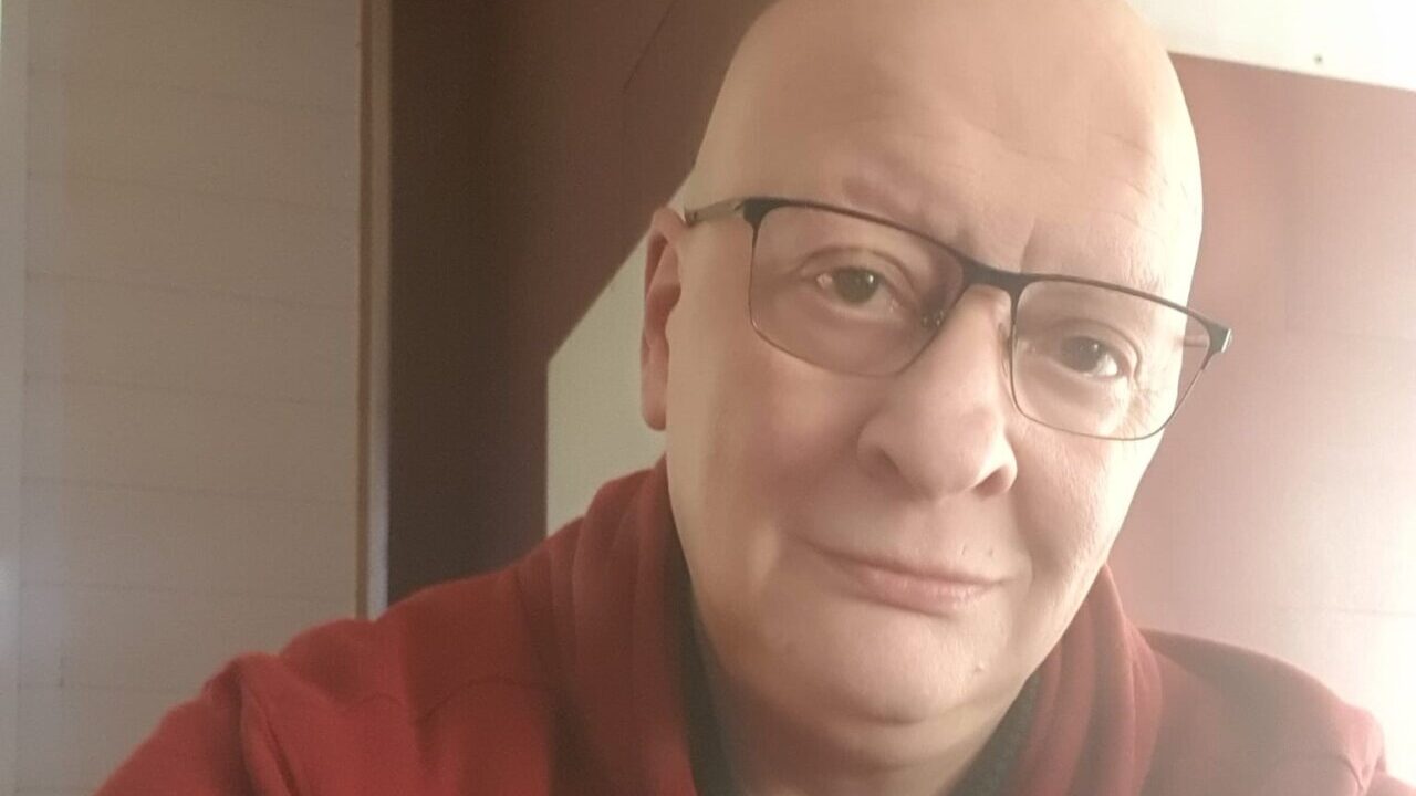 Retrato de un hombre con gafas y sudadera roja