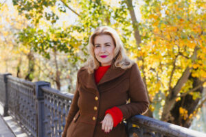 Rosana Largo posando en un entorno natural con árboles de otoño