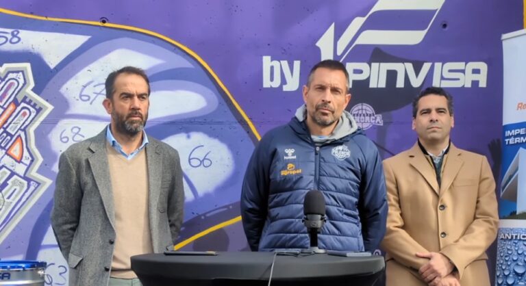 Tres personas en una rueda de prensa frente a un mural de baloncesto