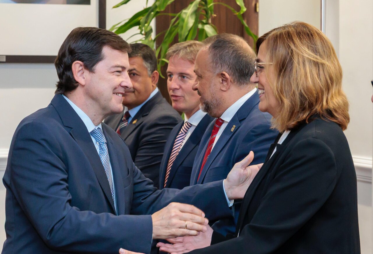Dos personas saludándose durante una reunión formal en septiembre.