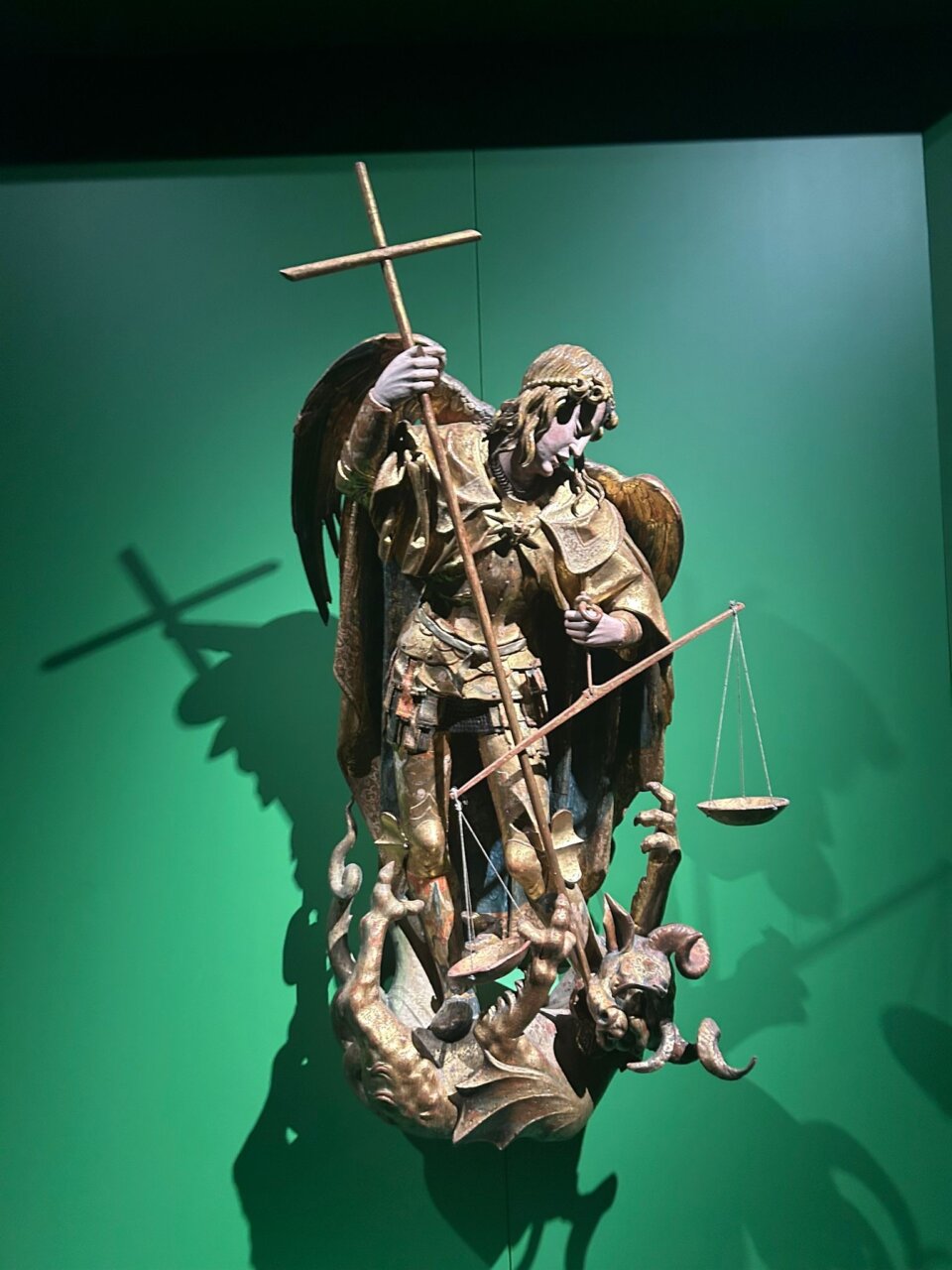 Escultura de San Miguel Arcángel sosteniendo una balanza y una cruz