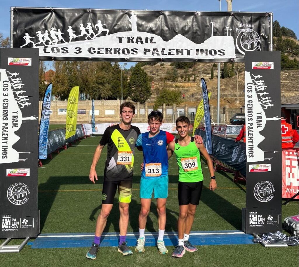 Atletas en la meta del Trail Tres Cerros Palentinos con banderas y un cartel