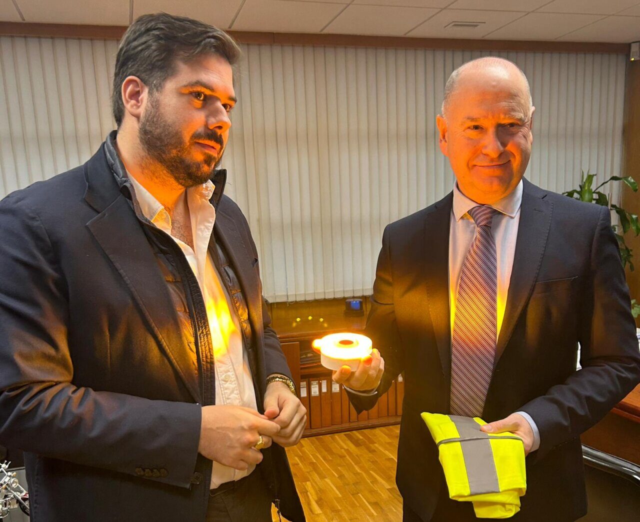 Dos hombres sosteniendo una luz V-16 y un chaleco reflectante