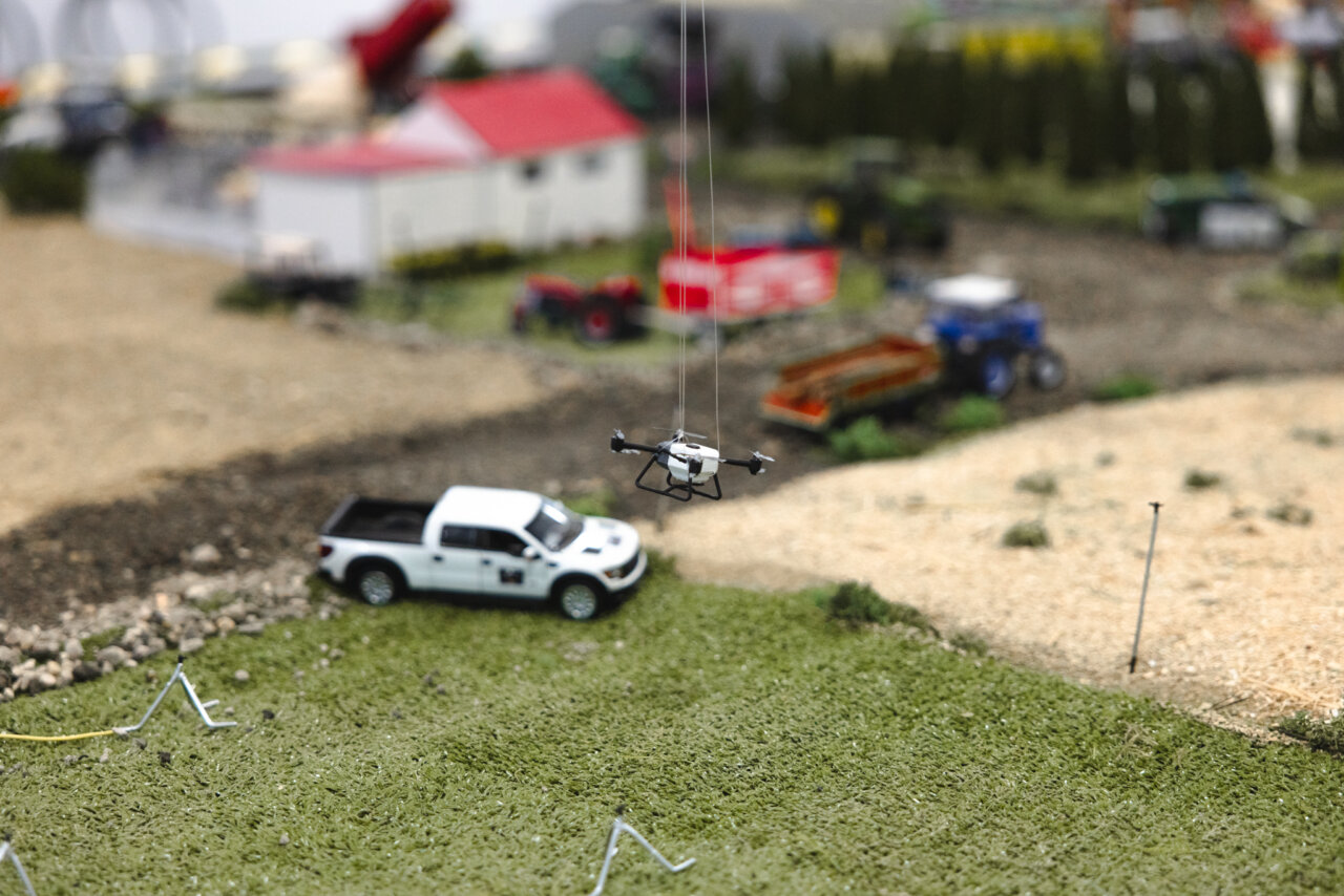 Maqueta de un dron sobre un paisaje agrícola en miniatura