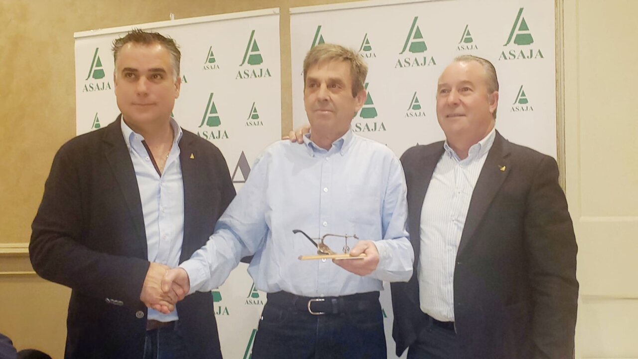 Tres hombres en un evento de Asaja con un fondo de logotipos