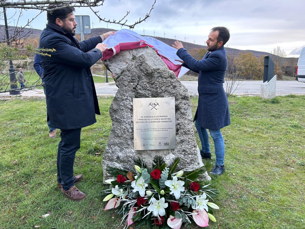 Homenaje a mineros en Barruelo de Santullán con flores y placa conmemorativa.