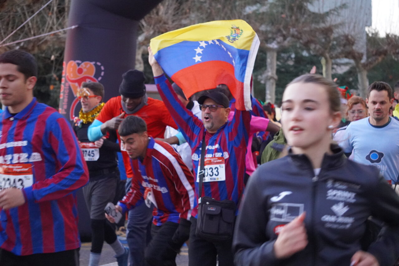 Corredores en la San Silvestre 2025 en Palencia, con banderas y ambiente festivo.