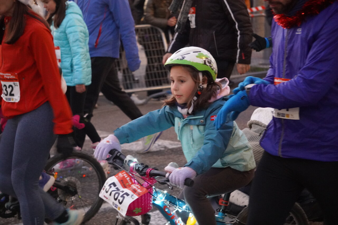 Niña montando en bicicleta durante la San Silvestre 2025 en Palencia