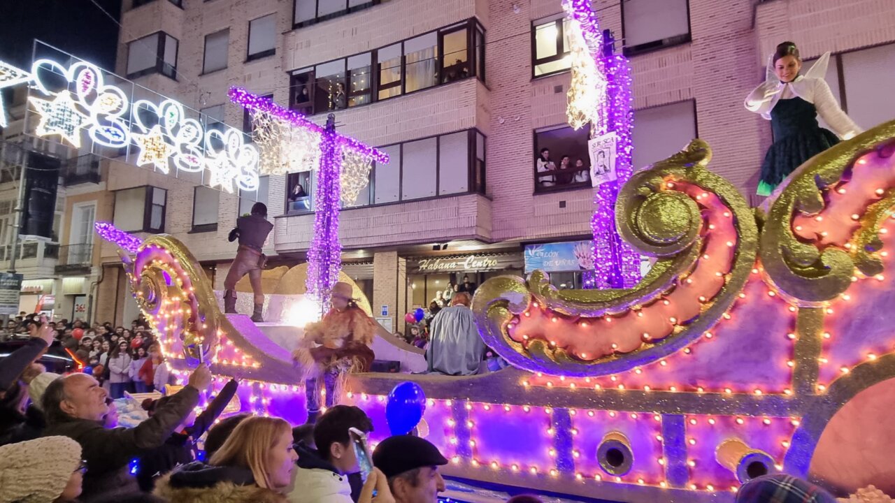 Desfile navideño en Palencia con carroza iluminada y espectadores