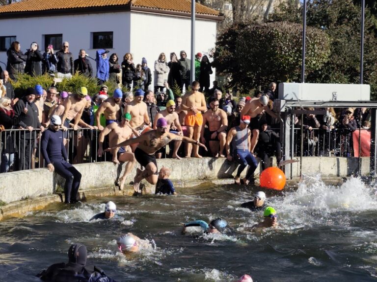 Participantes saltando al agua en una competencia de natación en invierno