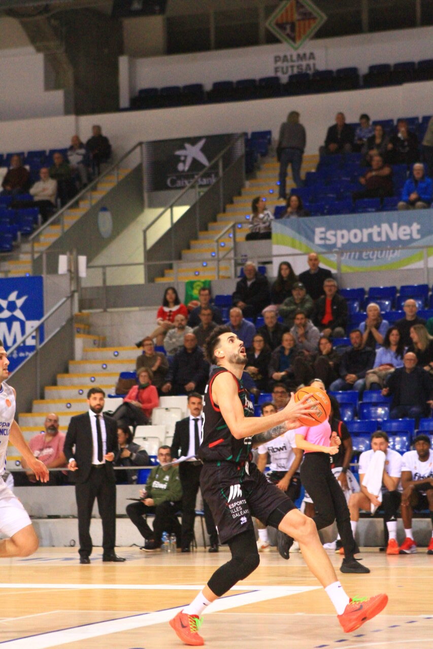 Jugador de baloncesto lanzando a canasta durante un partido en Palma.