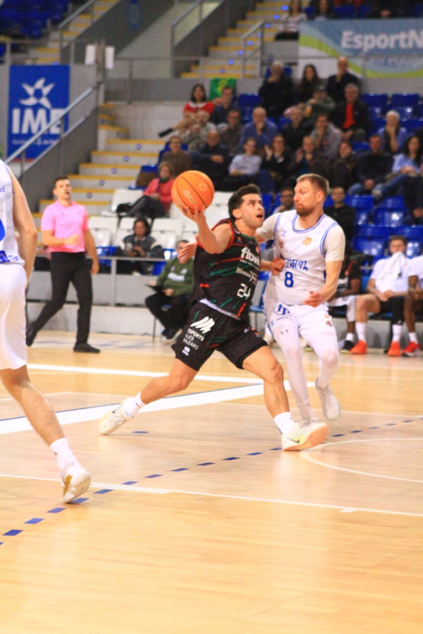 Jugador de baloncesto en acción durante un partido entre Palencia y Palma.