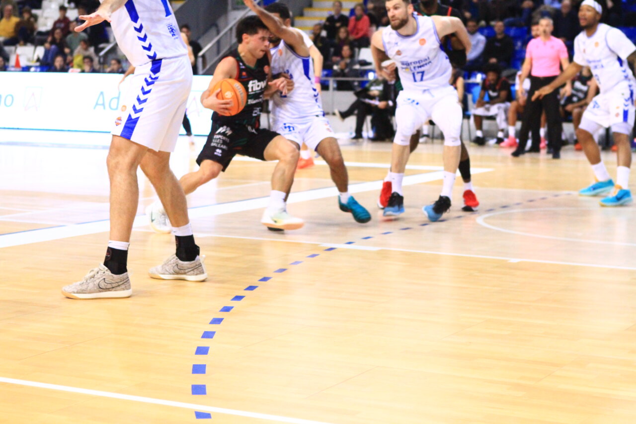 Jugadores de baloncesto en acción durante un partido entre Palencia y Palma.