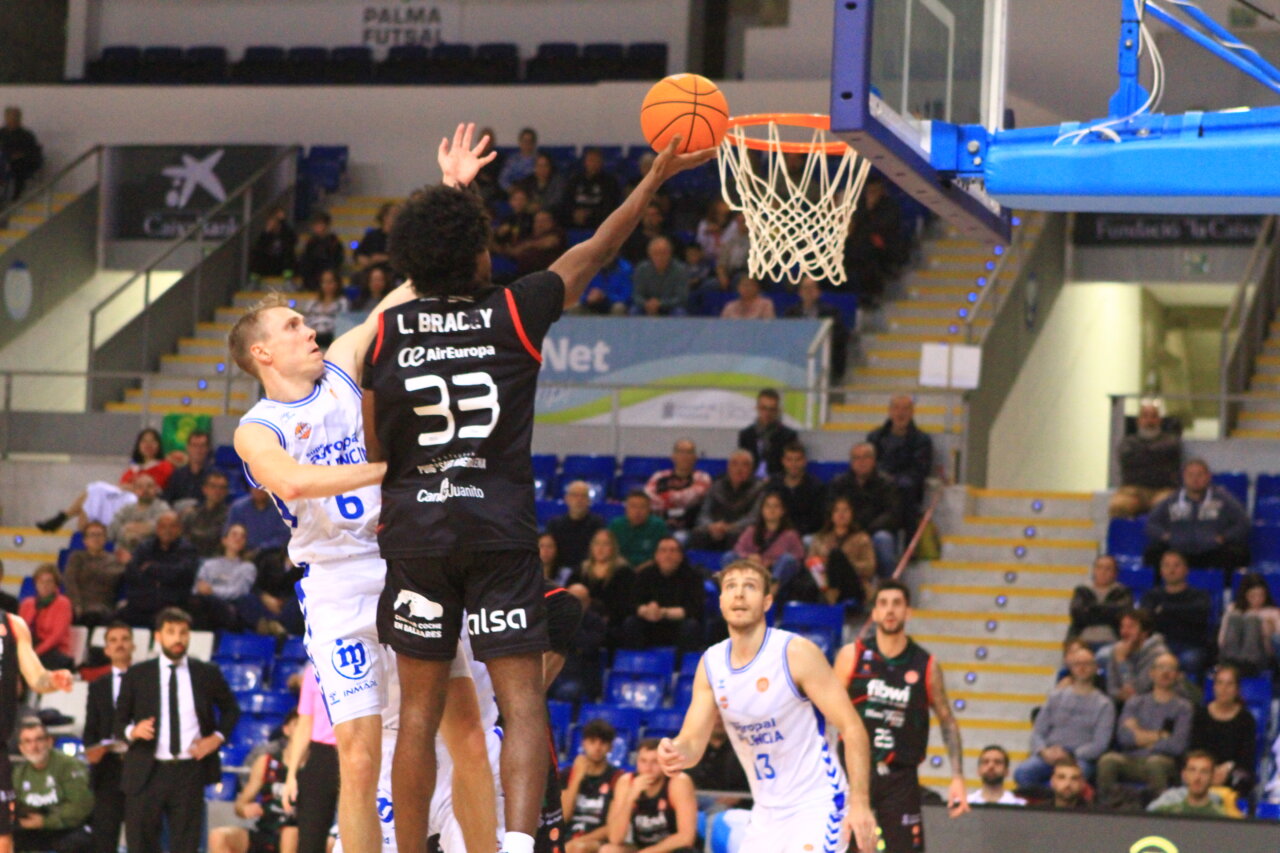 Jugador lanzando a canasta en un partido de baloncesto