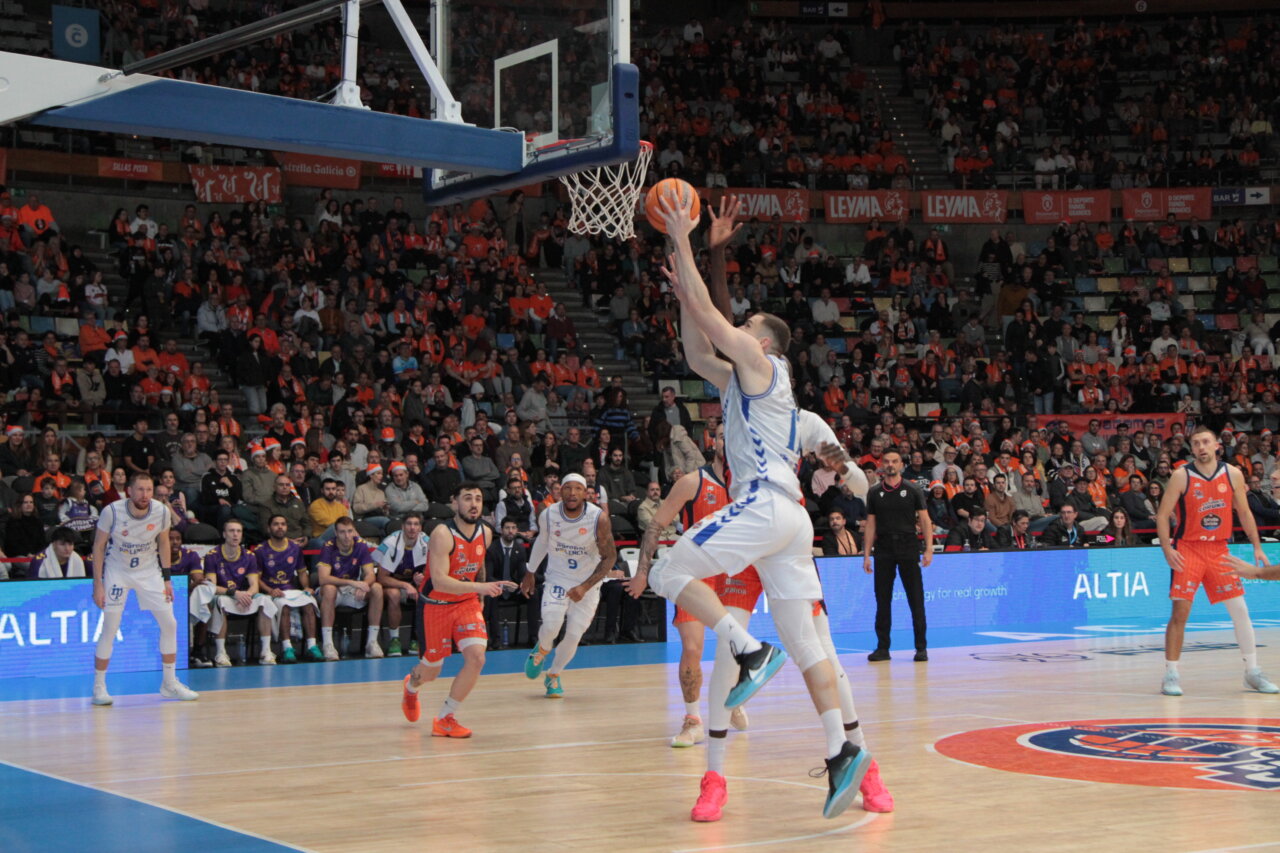 Jugador lanzando a canasta en partido de baloncesto entre Coruña y Palencia