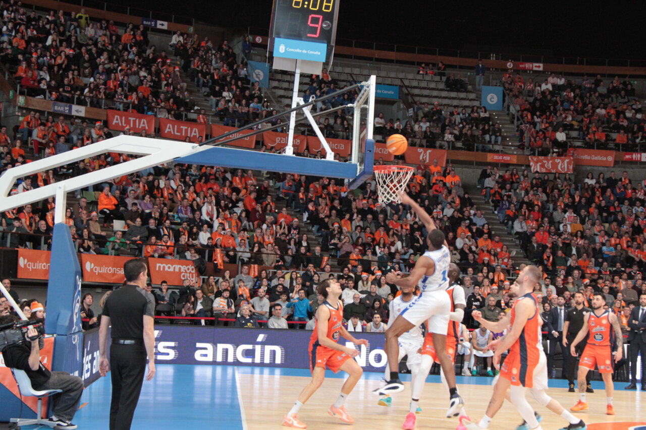 Jugadores de baloncesto en un partido en Coruña con un aro visible