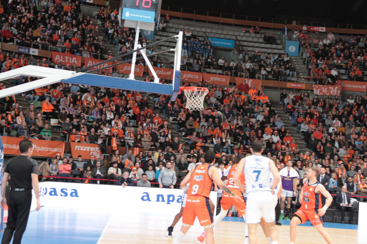 Jugadores de baloncesto en un partido en Coruña con público animado